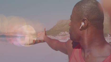Animation-Von-Lichtflecken-über-Einem-Lächelnden-Afroamerikanischen-Mann-Am-Strand
