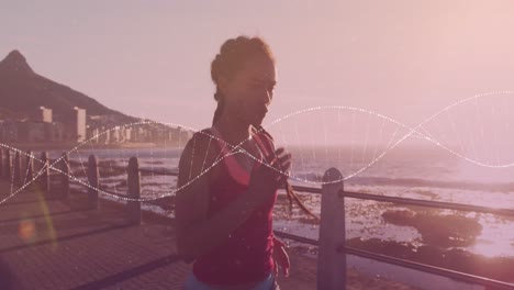 Animation-of-dna-strand-over-biracial-woman-running-on-promenade