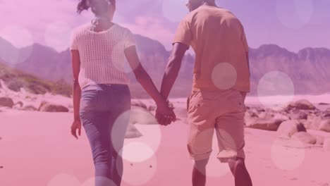 Animation-of-light-spots-over-african-american-couple-walking-and-holding-hands
