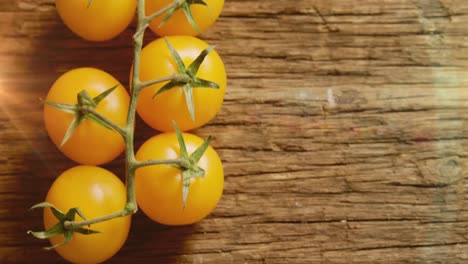 Animation-Von-Lichtflecken-über-Gelben-Tomaten-Auf-Holzhintergrund