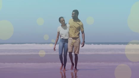 Animation-of-light-spots-over-african-american-couple-walking-and-embracing