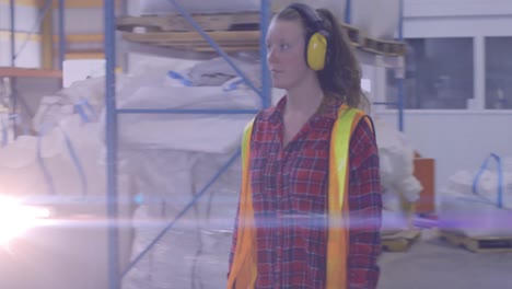 Animation-of-light-spots-over-caucasian-female-worker-with-safety-headphones-in-warehouse