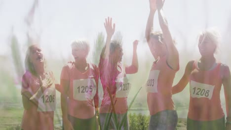 Animation-of-group-of-happy-caucasian-female-runners-raising-hands-over-landscape