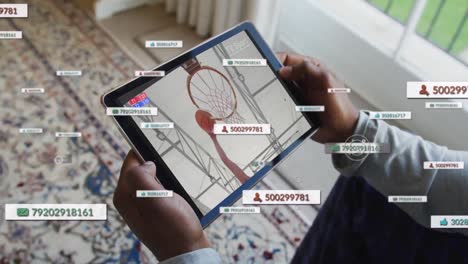 Animation-Von-Social-Media-Symbolen-über-Einem-Biracial-Mann,-Der-Auf-Einem-Tablet-Basketball-Schaut