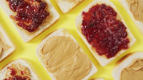 Close-up-of-multiple-peanut-butter-and-jelly-sandwiches-on-yellow-surface