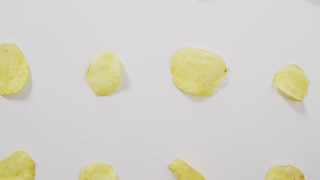 Close-up-of-potato-chips-with-copy-space-on-white-surface