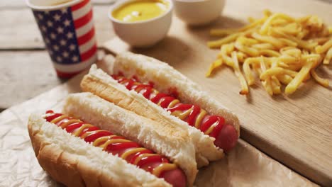 Vídeo-De-Hot-Dogs-Con-Mostaza,-Ketchup-Y-Patatas-Fritas-Sobre-Una-Superficie-De-Madera