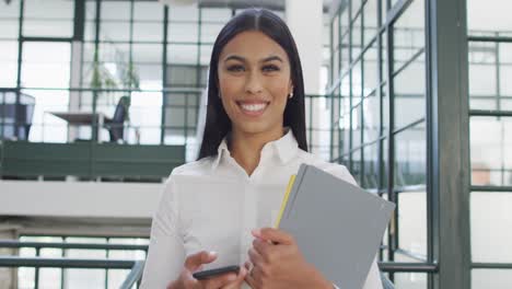 Portrait-of-happy-biracial-businesswoman-at-office