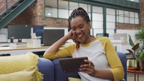 Glückliche-Afroamerikanische-Geschäftsfrau,-Die-Im-Büro-Ein-Tablet-Nutzt