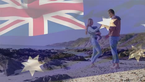 Animation-of-flag-of-australia-over-caucasian-parents-with-child-dancing-at-beach