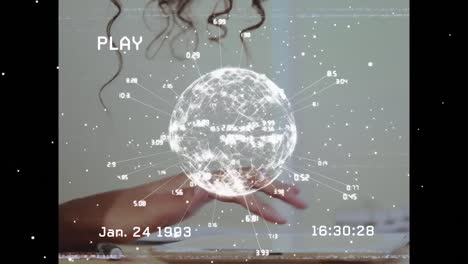Animation-of-globe-with-numbers-over-hand-of-biracial-woman-working-on-laptop