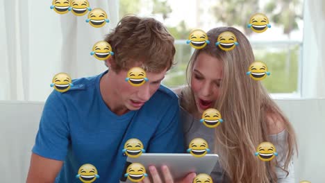 Animation-Von-Emoticons-über-Einem-Glücklichen-Kaukasischen-Teenager-Paar,-Das-Ein-Tablet-Benutzt