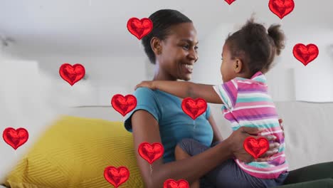 Animation-of-heart-icons-over-happy-african-american-mother-embracing-daughter