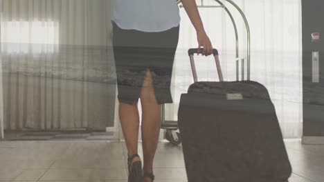 Animation-of-sea-over-biracial-businesswoman-with-luggage