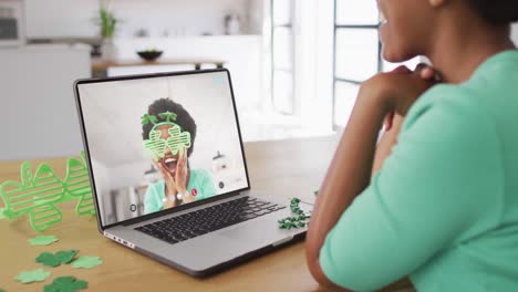Smiling-african-american-woman-wearing-clover-shape-glasses-on-video-call-on-laptop