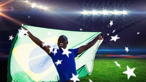 Animation-Von-Sternen,-Die-über-Einem-Afrikanisch-amerikanischen-Mann-Schweben,-Der-Die-Brasilianische-Flagge-Im-Stadion-Hält