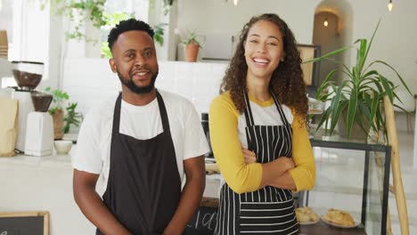 Portrait-of-happy-african-american-male-cafe-owner-and-biracial-female-barista-at-cafe