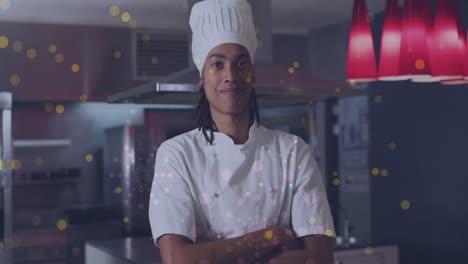 Animation-of-spots-over-happy-biracial-male-chef-with-arms-crossed
