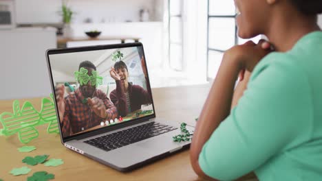 Smiling-diverse-couple-wearing-clover-shape-items-on-video-call-on-laptop