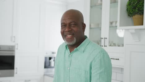 Portrait-of-smiling-senior-african-american-man-looking-at-camera-in-kitchen