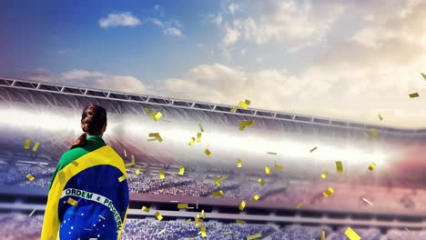 Animation-Von-Konfetti,-Die-über-Dem-Rücken-Einer-Frau-Mit-Brasilianischer-Flagge-Im-Stadion-Schwebt