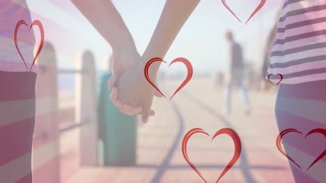 Animation-of-hearts-falling-over-diverse-couple-holding-hands