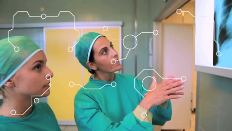 Animation-Eines-Integrierten-Schaltkreises-über-Zwei-Kaukasischen-Ärztinnen,-Die-über-Röntgenfotos-Sprechen