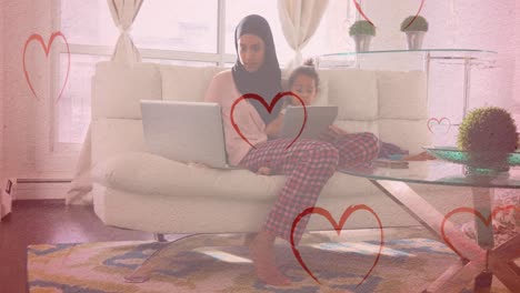 Animation-of-hearts-falling-over-biracial-woman-and-her-daughter-using-laptop-and-tablet