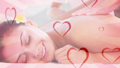 Animation-of-hearts-falling-over-caucasian-woman-in-spa-during-massage