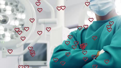 Animation-of-hearts-over-biracial-male-surgeon-wearing-face-mask-and-cleaning-hands