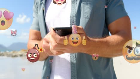 Animation-of-emoticons-over-midsection-of-caucasian-man-using-smartphone-outdoors