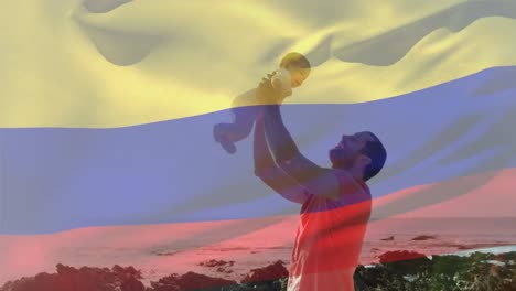 Animación-De-La-Bandera-De-Colombia-Sobre-Un-Hombre-Caucásico-Con-Un-Bebé-En-La-Playa