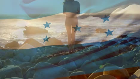 Animation-of-flag-of-honduras-over-caucasian-woman-at-beach