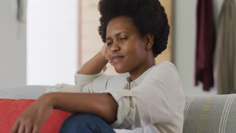 Glückliche-Afroamerikanische-Frau-Sitzt-Auf-Dem-Sofa-Im-Wohnzimmer