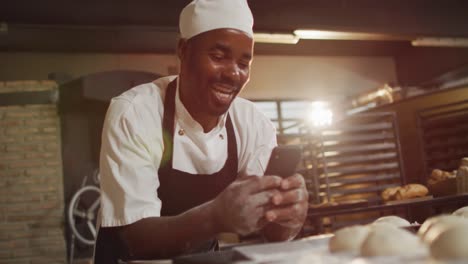 Animation-of-happy-african-american-male-baker-using-smartphone