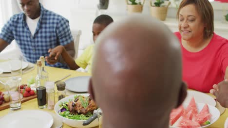 Animation-of-african-american-family-praying-before-meal-at-home