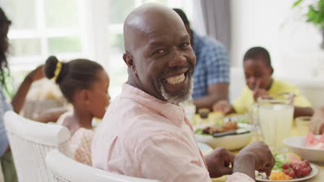 Glücklicher-Afroamerikanischer-Großvater,-Der-Zu-Hause-Mit-Der-Familie-Zu-Mittag-Isst