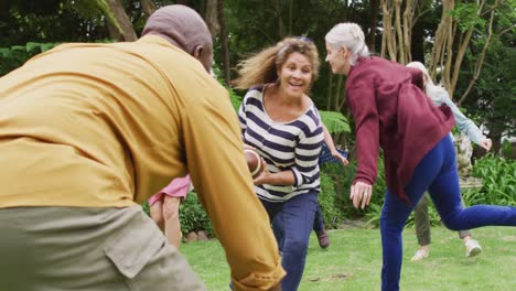 Animation-of-happy-diverse-female-and-male-senior-friends-playing-american-football-in-garden