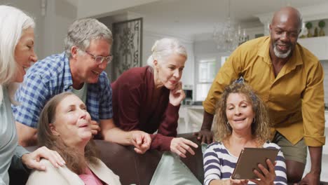 Animation-of-happy-diverse-female-and-male-senior-friends-using-tablet-at-home