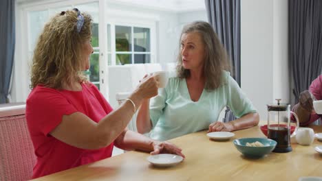 Animation-of-happy-diverse-female-senior-friends-drinking-coffee-at-home