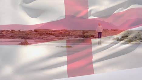 Animation-of-flag-of-england-over-senior-caucasian-woman-on-beach