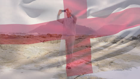 Animation-of-flag-of-england-over-happy-senior-caucasian-man-using-smartphone-on-beach
