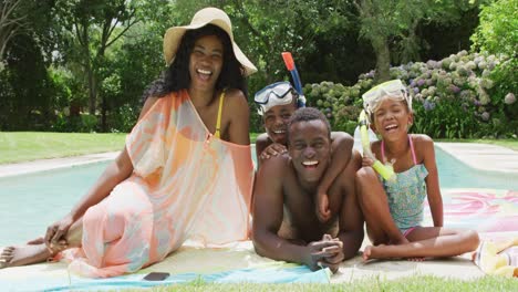 Glückliche-Afroamerikanische-Familie-Mit-Strandausrüstung,-Die-Für-Ein-Foto-Am-Pool-Posiert