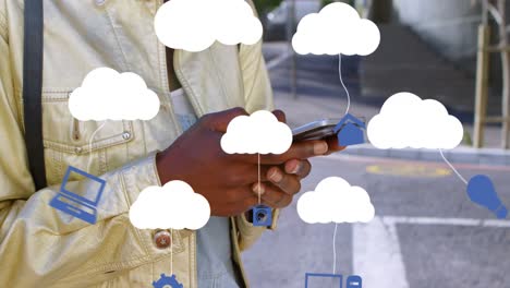 Animation-Von-Wolken-Mit-Elektronischen-Geräten-über-Einer-Afroamerikanischen-Frau,-Die-Ihr-Smartphone-Benutzt