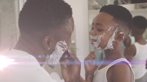 Animation-of-lights-over-happy-african-american-father-and-son-shaving-beards