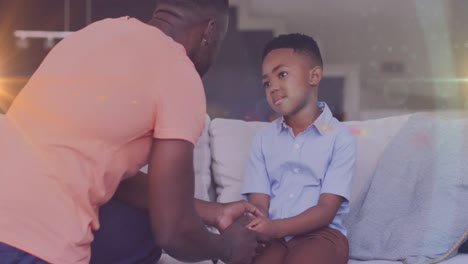 Animation-of-lights-over-african-american-father-and-son-having-serious-conversation