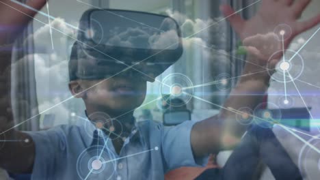 Animation-of-network-of-connections-over-happy-african-american-boy-wearing-vr-headset