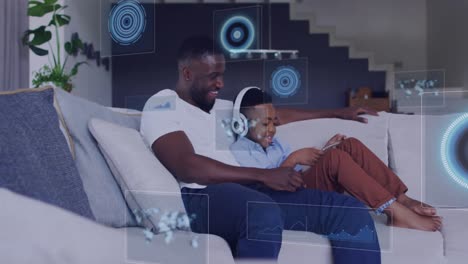 Animation-of-diverse-data-over-happy-african-american-father-and-son-using-tablet