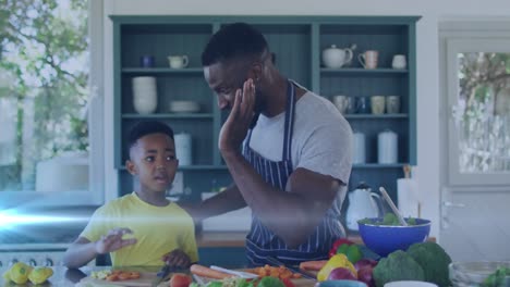 Animation-of-lights-over-happy-african-american-father-and-son-preparing-meal-and-clapping-hands