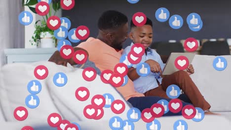 Animation-Von-Social-Media-Symbolen-über-Glücklichem-Afroamerikanischen-Vater-Und-Sohn-Mit-Tablet
